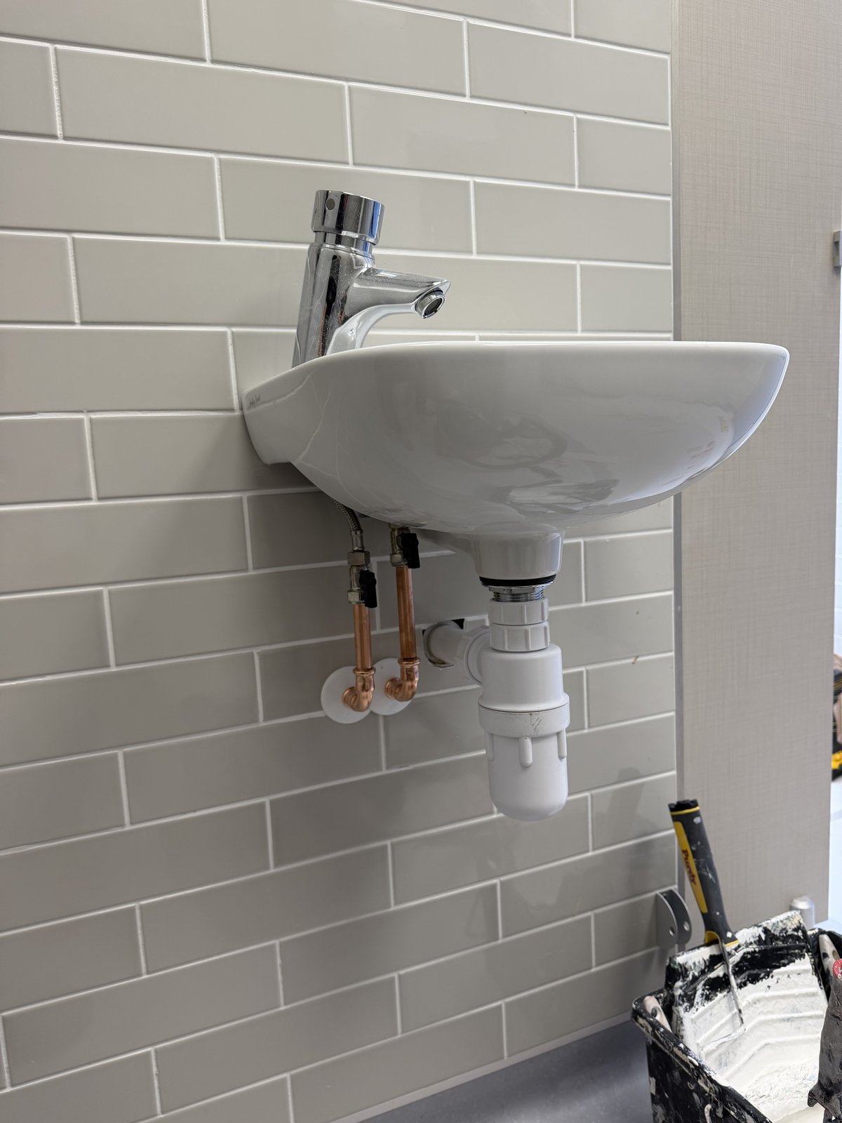 Cloakroom basin with green metro tiles